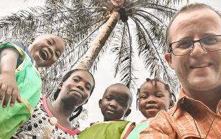 Misjonarz ksiądz Marek Kapłon na zdjęciu razem z dziećmi mieszkającymi w Kamerunie